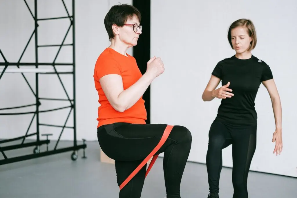 Kinésithérapeute aidant un patient à réaliser des exercices avec une bande élastique